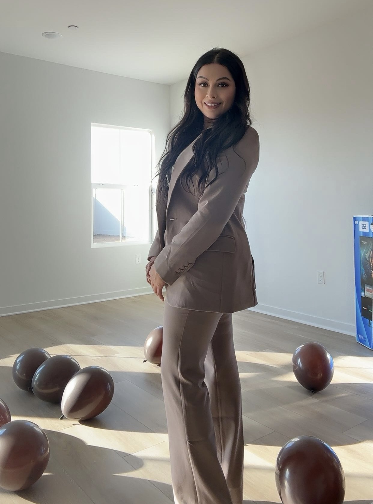 Taty Recinos, Bakersfield CA Realtor, standing in front of a home she helped a client purchase